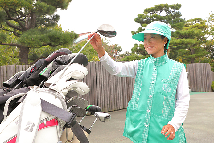 クラブを取るキャディ